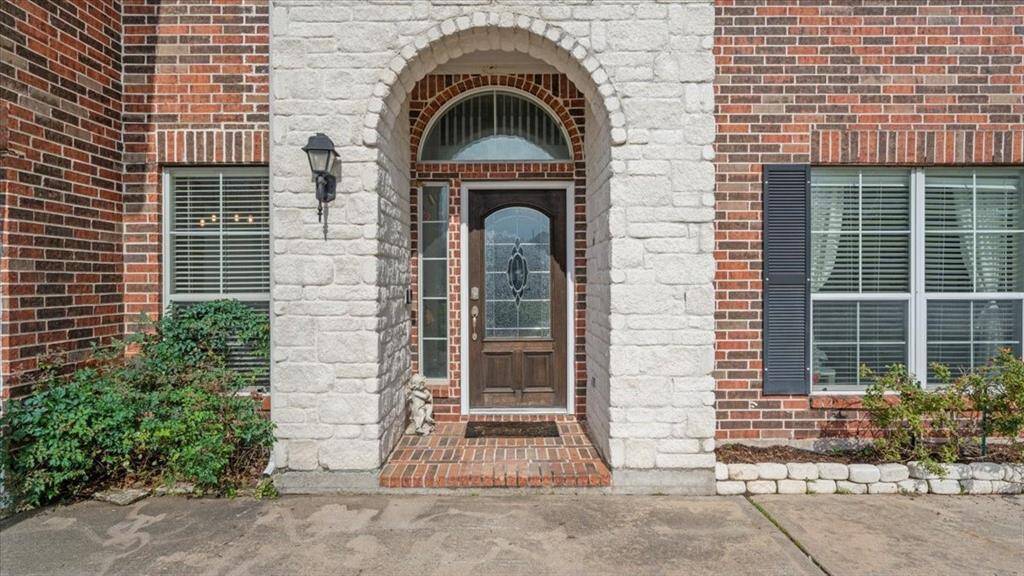 Charming front entrance with a spacious driveway offering ample parking.
