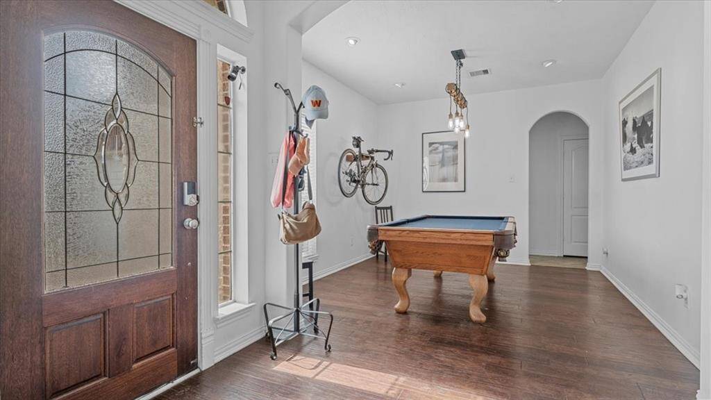 The formal dining room connects to the kitchen and is currently staged as a game room, showcasing its versatility.