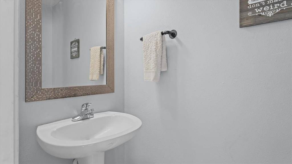 A guest-friendly half bath is thoughtfully positioned for convenience and privacy.