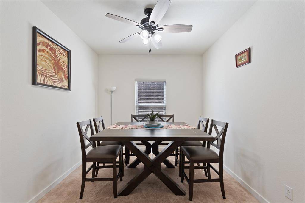 With a ceiling fan for added comfort and abundant natural light, this dining room offers a warm and inviting atmosphere for hosting family and guests.