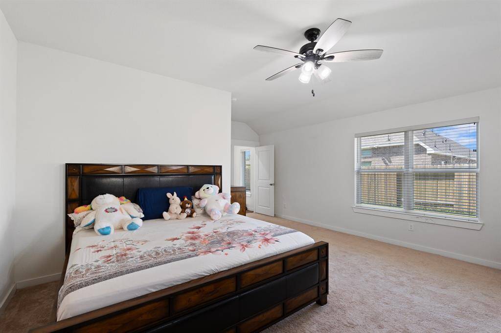 Primary bedroom suite featuring an oversized window, plush carpeting and high ceilings, creating a luxurious and relaxing retreat.