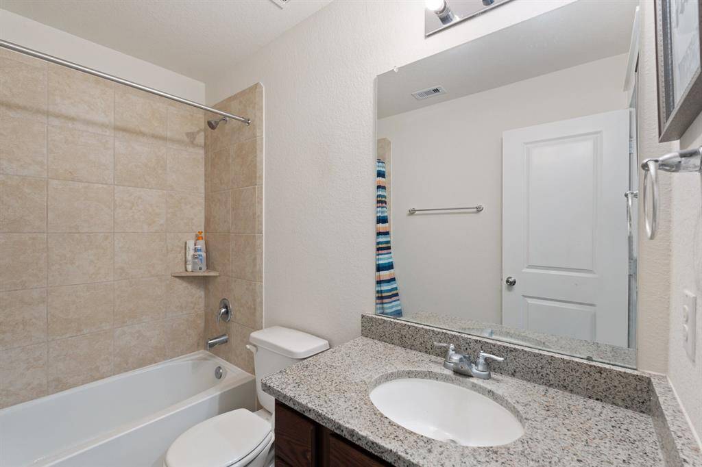 Well-appointed secondary bathroom on the main floor, featuring an oversized mirror and a convenient tub/shower combo. Perfect for family or guest use with ample space and functionality.
