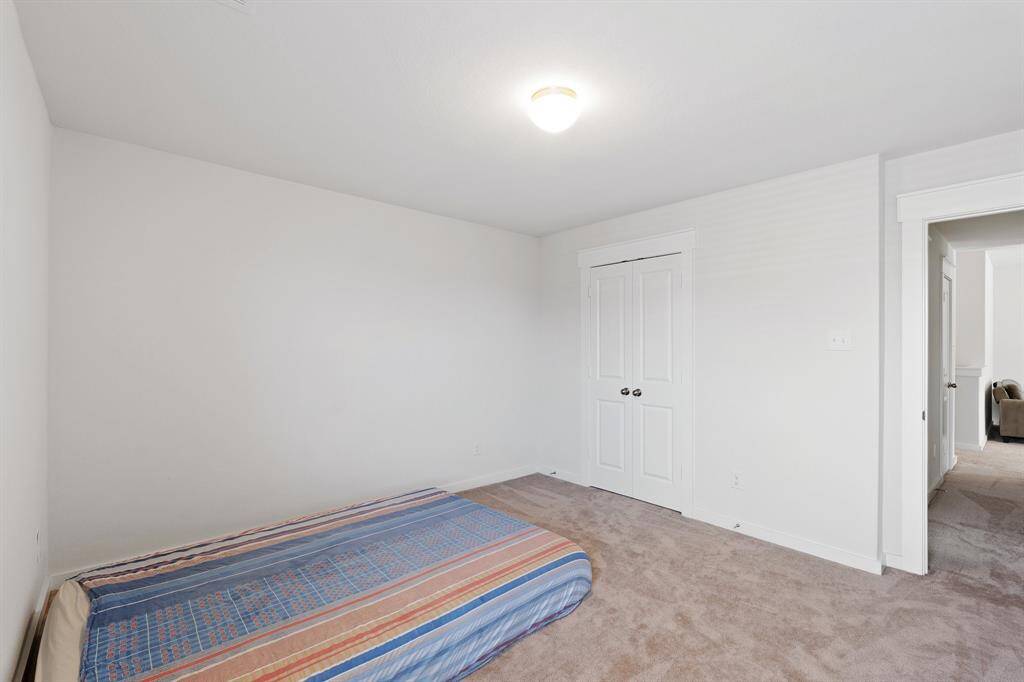 Another view of the Charming secondary bedroom with double-door closet, plush carpet, and easy access nearby bathroom.