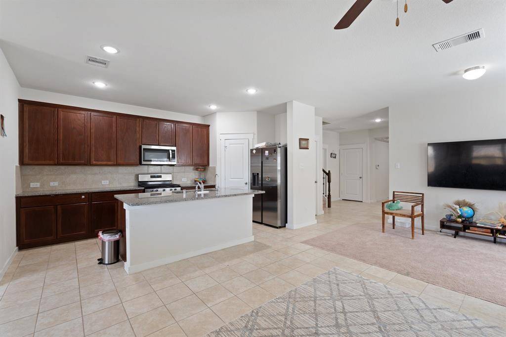 This spacious living room seamlessly connects with the entryway, dining room, and gourmet kitchen, creating an open, airy floor plan ideal for entertaining.