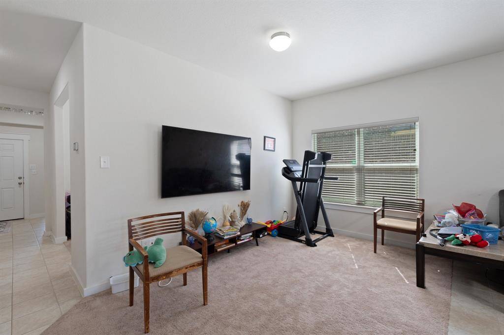 Spacious and inviting living room featuring plush carpeting and an oversized window that fills the space with natural light. Perfectly positioned near the entryway, this area flows seamlessly into the open-concept kitchen, creating an ideal layout for entertaining and daily living.