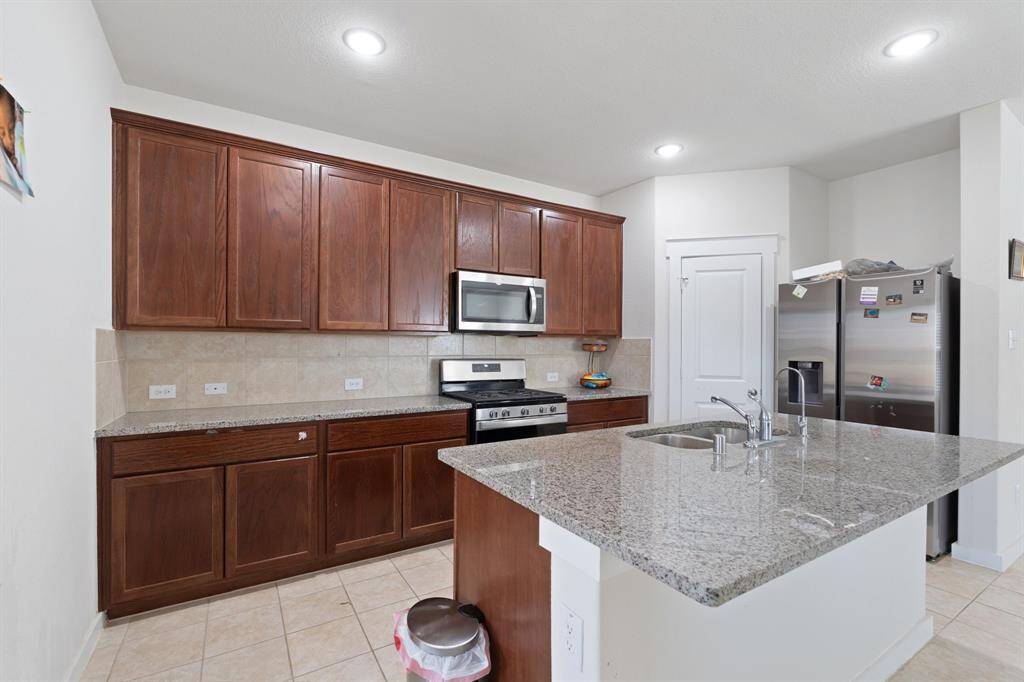 The gourmet kitchen features a spacious island with breakfast bar, perfect for meal prep or casual dining. Sleek countertops offer both elegance and practicality.