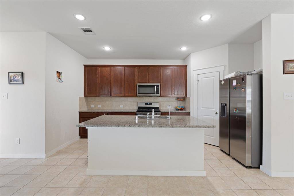 Another view of the kitchen, highlighting the expansive island and sleek countertops. This space effortlessly combines beauty and functionality, ideal for cooking and socializing.
