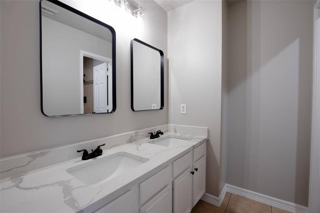 Secondary bathroom with double sinks and quartz countertops
