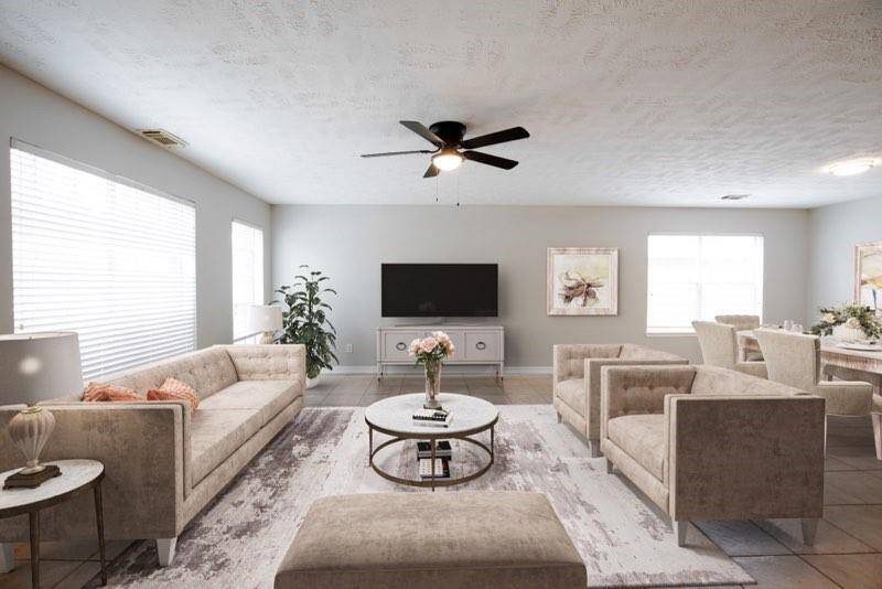 Virtually staged den with fireplace off the kitchen and view of backyard