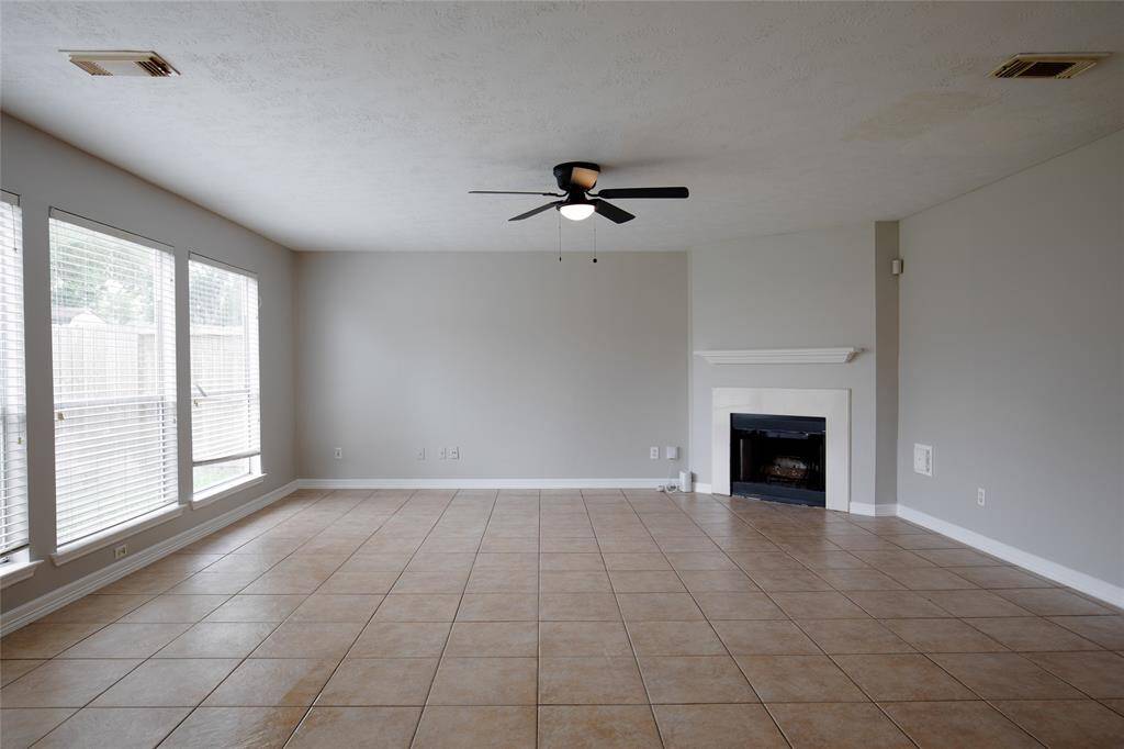 den off the kitchen with fireplace and view of backyard