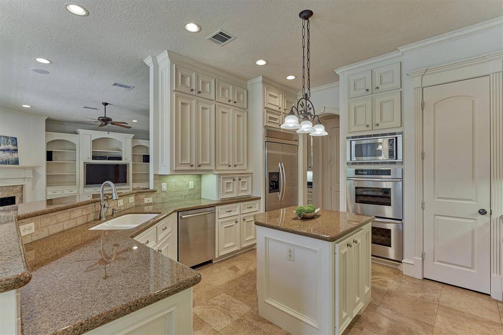 Kitchen features a built-in refrigerator, double ovens and breakfast bar opening to den!