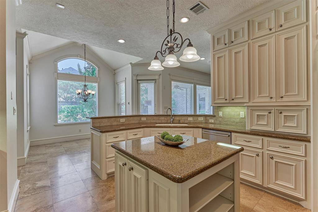 Kitchen opens to the adjoining den and breakfast room with vaulted ceiling and superb views of the tranquil backyard oasis!