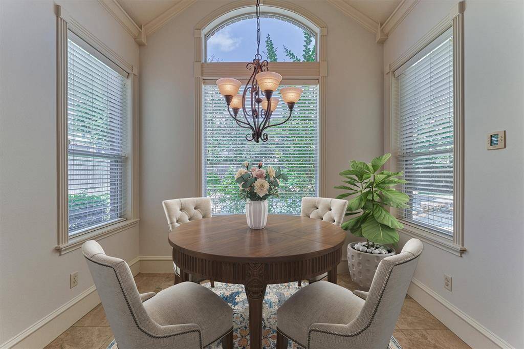 The breakfast room features a vaulted ceiling and beautiful views of the covered back patio and sparkling pool and spa!
