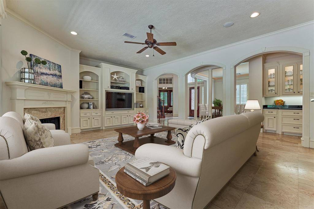 Spacious den showcases a fireplace and a wall of built-ins. *This photo is virtually staged*