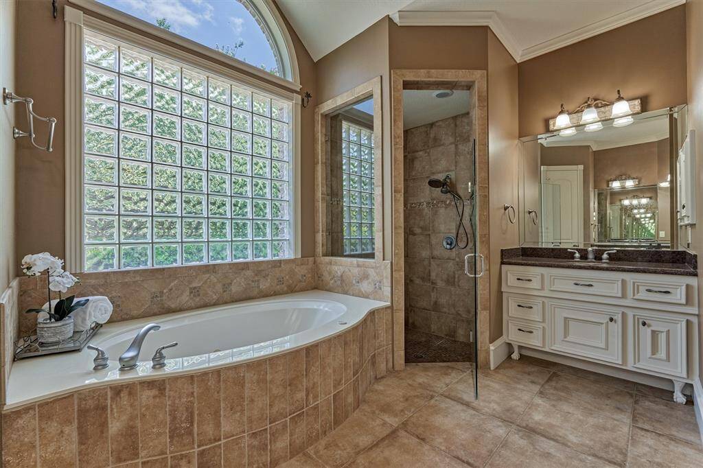 Spa-like primary bathroom boasts a soaking tub, separate walk-in shower, and dual sinks.