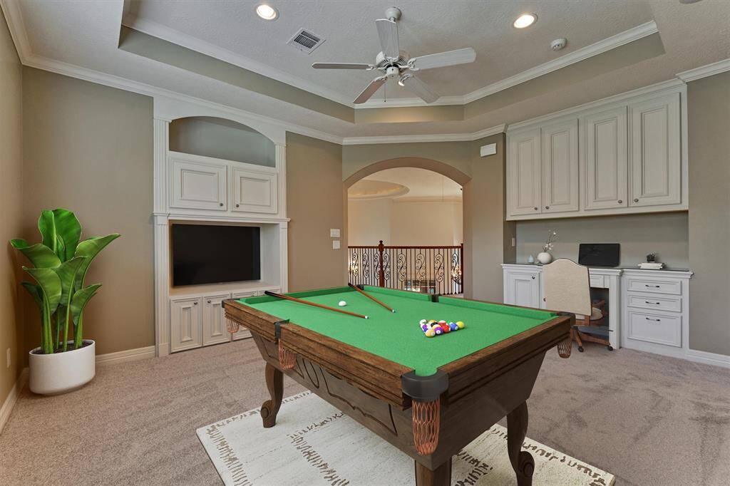 Built-in desk and cabinetry provides lots of organization and storage space in the game room. *This photo is virtually staged*