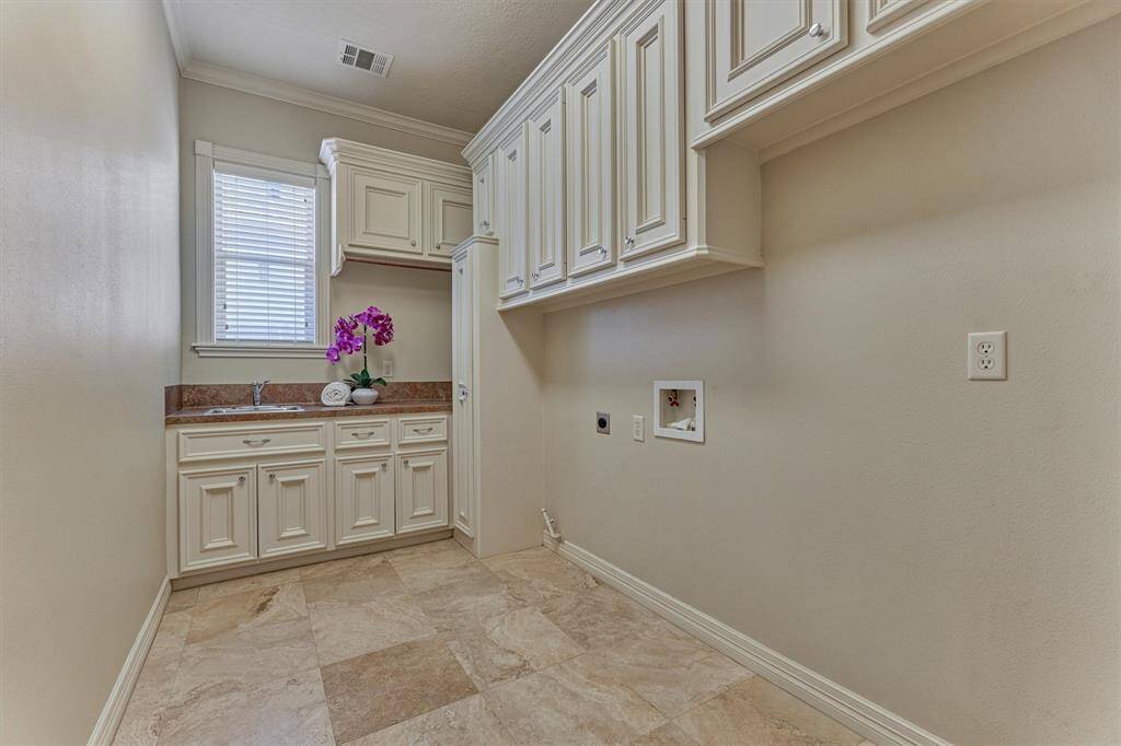 Utility room with sink and tons of cabinetry for extra storage space!