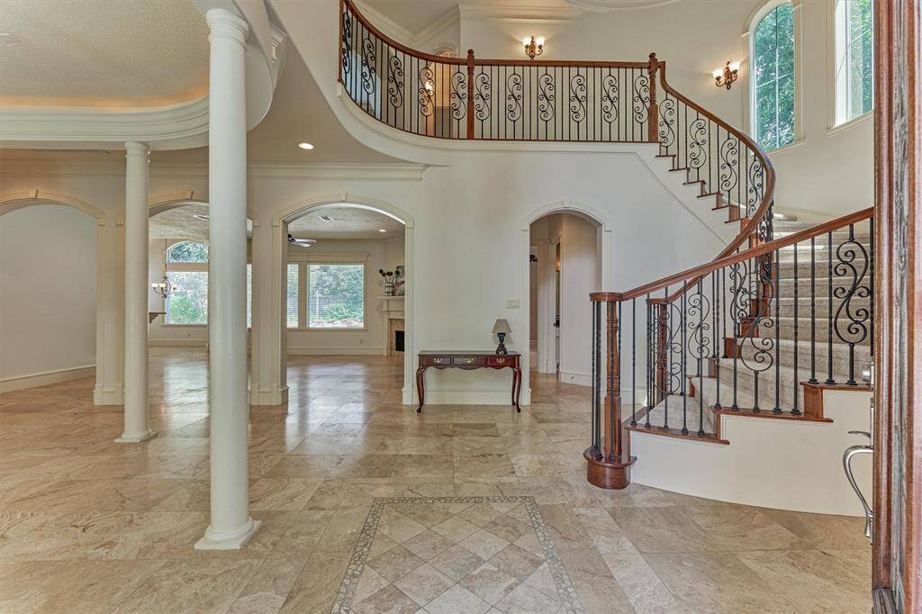 Step inside the grand 2-story foyer entry boasting a stunning curved stairway, continuous tile flooring throughout, and soaring ceilings with fresh painting throughout.
