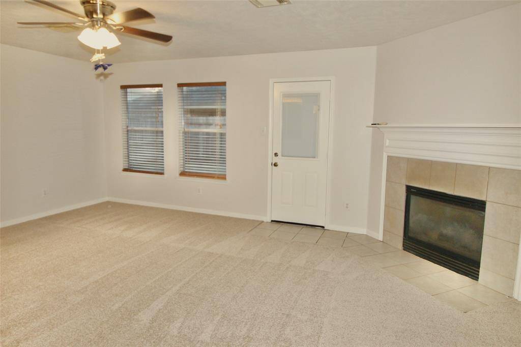 The spacious family room features access to the backyard, lots of natural light and a cozy fireplace- "Home is Occupied"