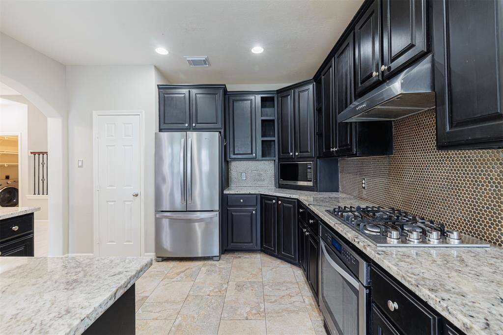The kitchen also features a gas cook top and custom real wood cabinets.