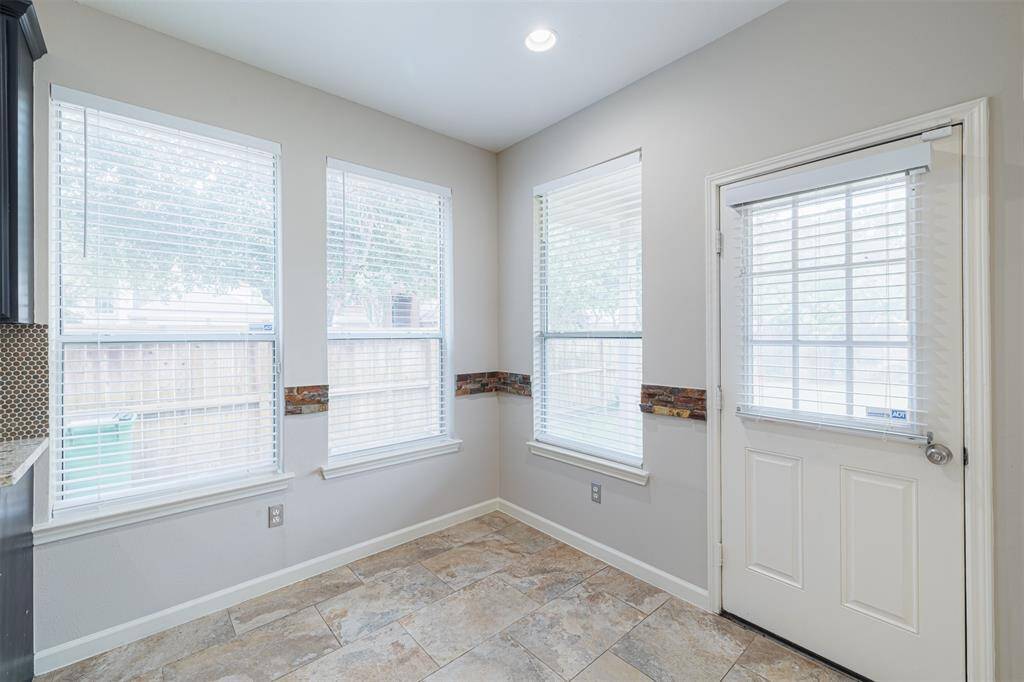 Breakfast room located off the kitchen with a door leading out to the covered back patio.