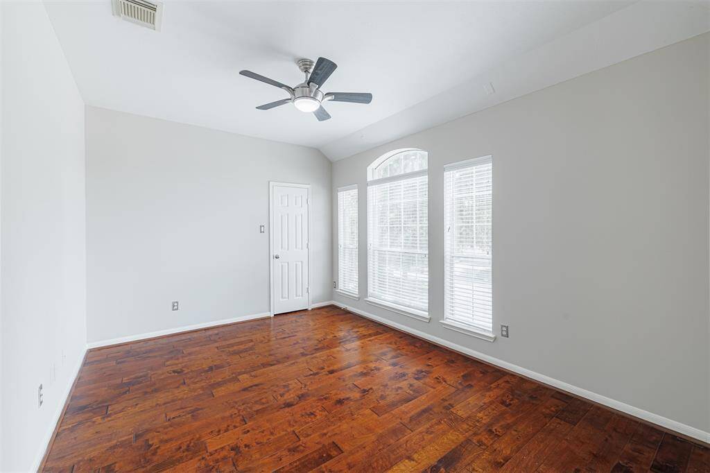 Large game room located upstairs with hand-scraped flooring and a walk-in game closet.