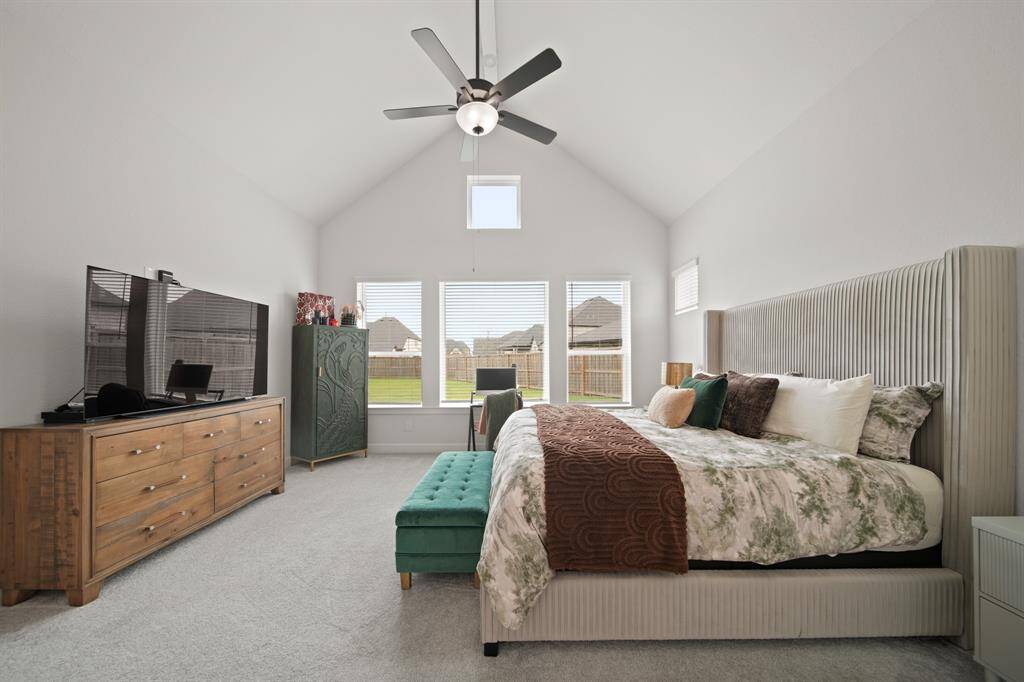 This bright and spacious primary bedroom also features a vaulted ceiling and large windows that allow plenty of natural light
