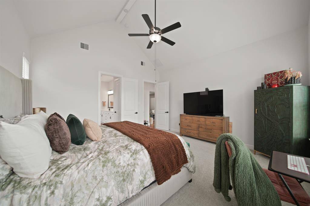 This bright and spacious primary bedroom also features a vaulted ceiling and large windows that allow plenty of natural light
