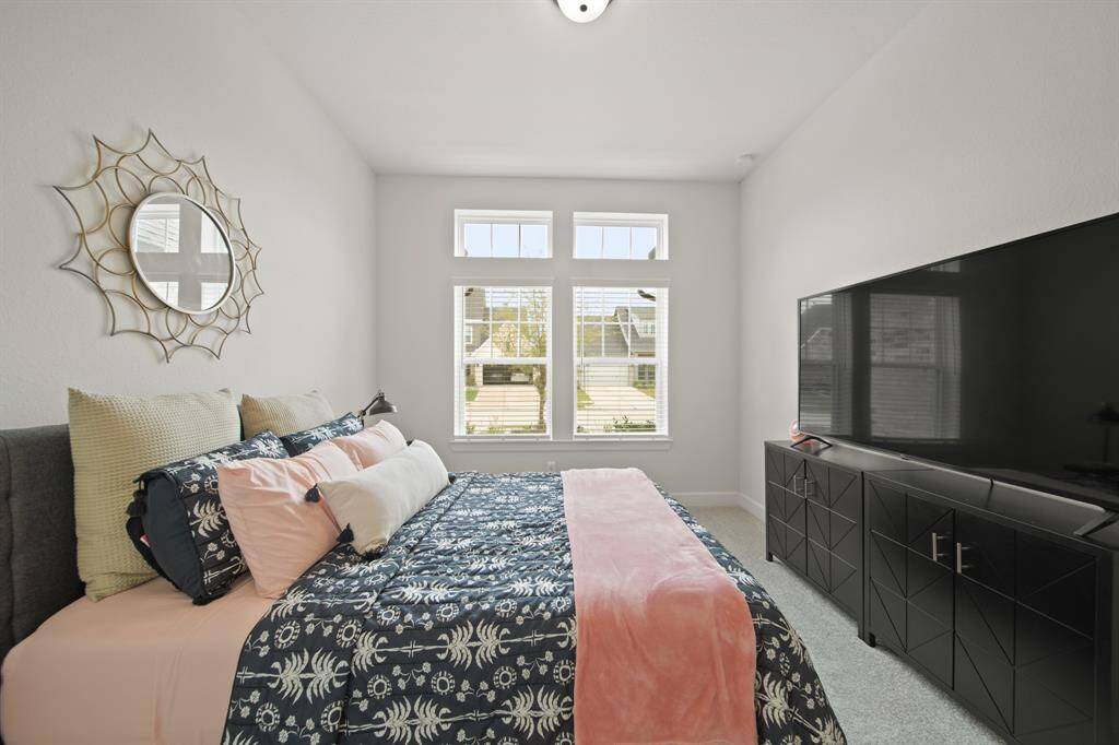 This bright and cozy bedroom features a large window allowing natural light, creating a perfect space for relaxation.