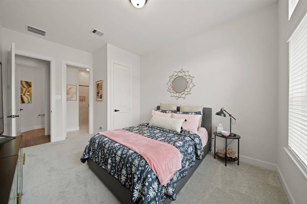 This bright and cozy bedroom features a large window allowing natural light, creating a perfect space for relaxation.
