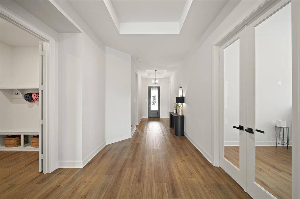 This inviting entryway features a modern design with light wood flooring and white walls.