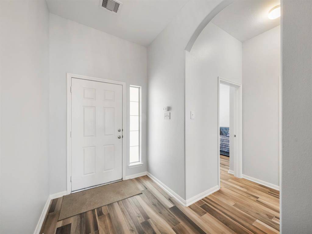 Gorgeous neutral tones tile flooring and light and bright walls create an inviting tone as you enter the home. Picture show hall leading to the 2 secondary bedrooms!