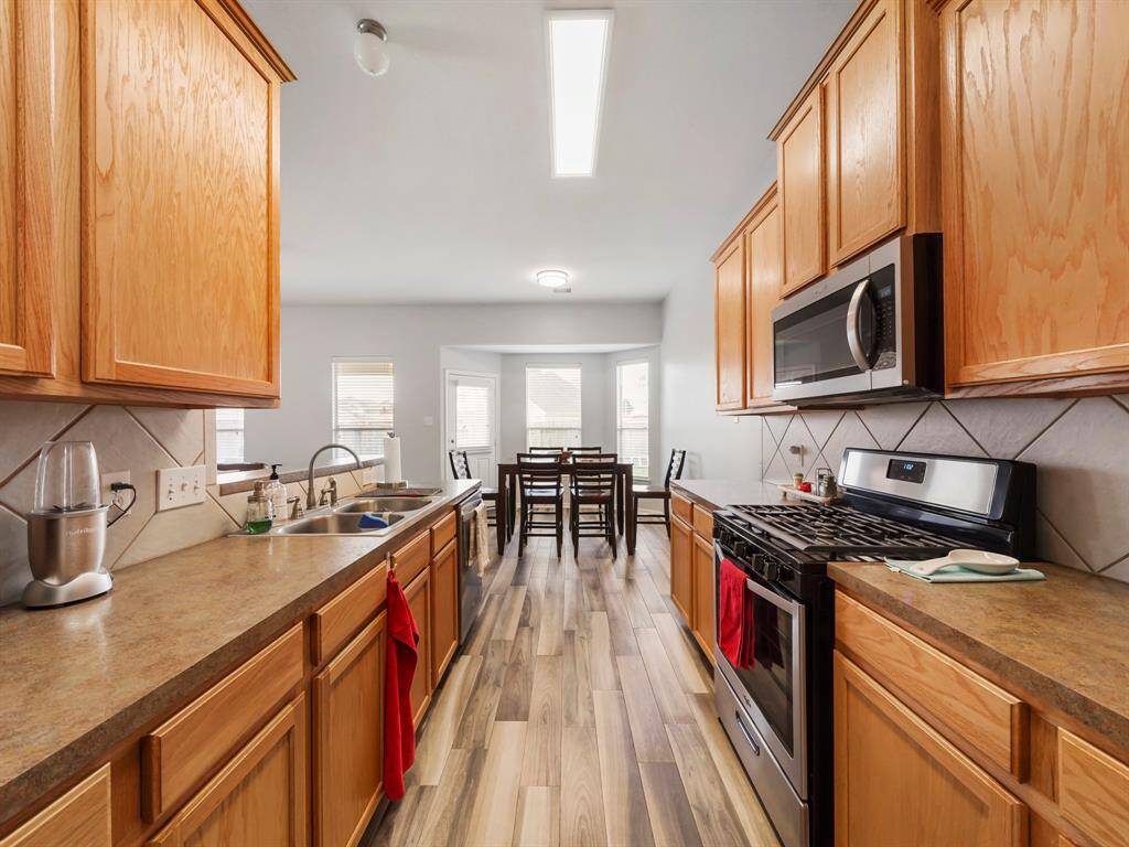 Kitchen features new dishwasher, refrigerator and microwave stainless steel whirlpool appliances! The warm cabinets are complimented by the neutral formica countertops and tile backsplash!