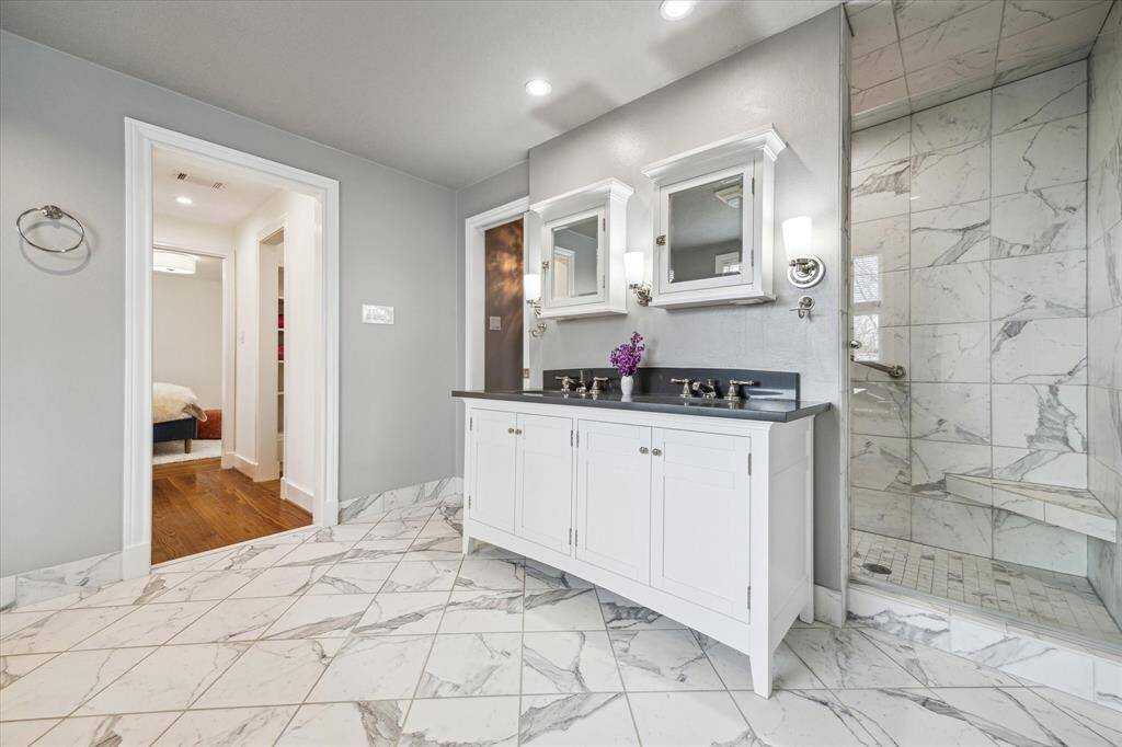 Bathed in stunning natural light, the Primary Bath features fixtures and vanity with dual sinks by Restoration Hardware, spacious shower, and private water closet.