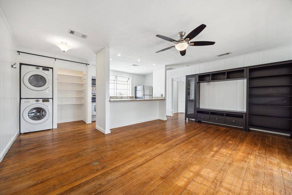 Entertainment center anchored by bookcases, full-size washer and dryer, pantry.