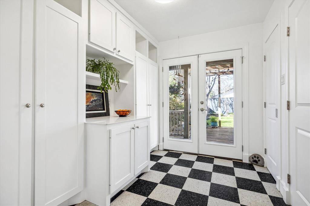 Kitchen transitions onto backyard deck through large mudroom with pantry, shelving and closets.