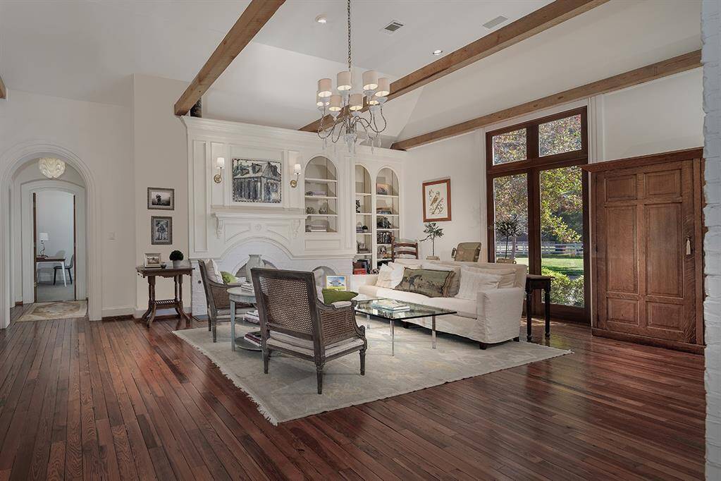 Rich wood beams in the formal living room, a cozy fireplace and built-ins make this a great conversation room.