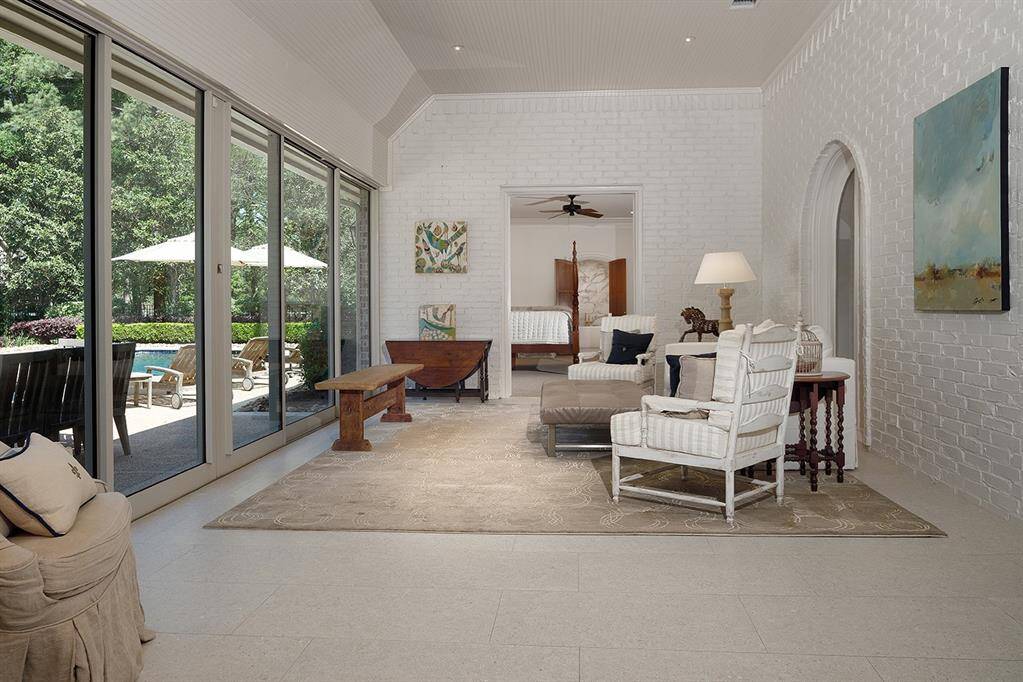 The sunroom with Nano doors that open to the patio and pool is a great place to read and relax.