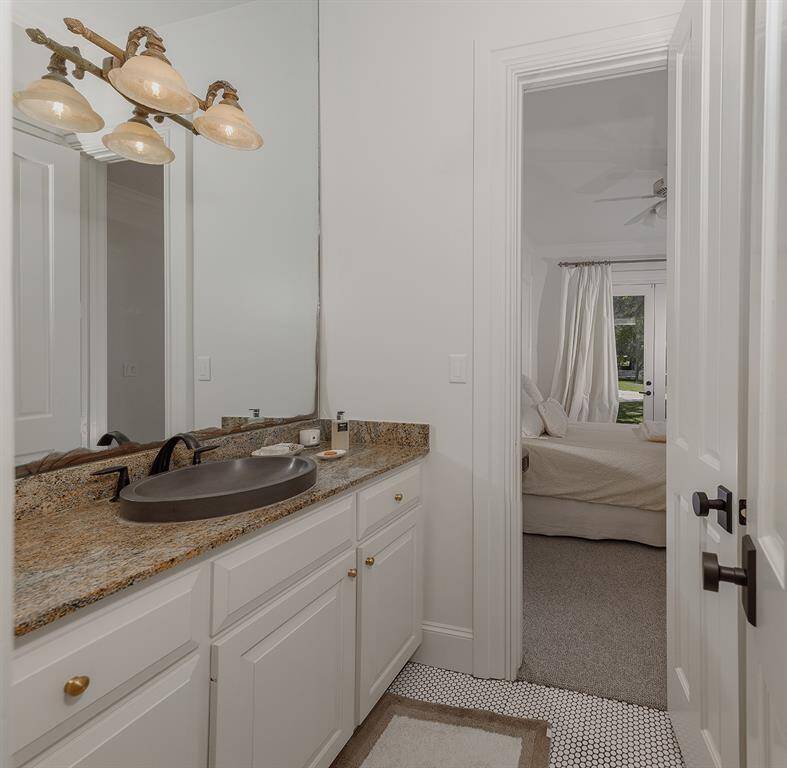 Remodeled guest bath with granite counters and penny tile flooring.