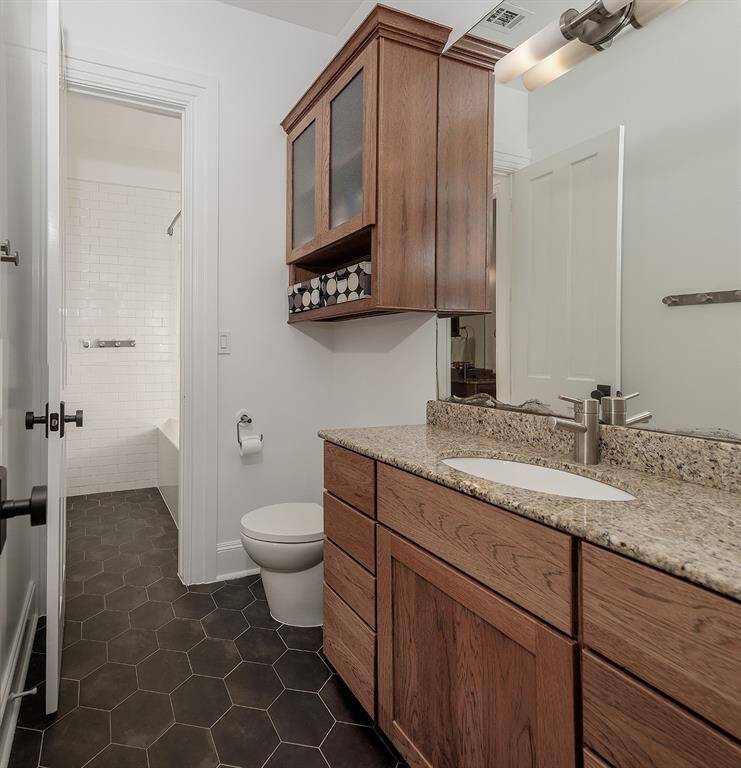 This remodeled Jack and Jill bath is shared with a fourth bedroom.