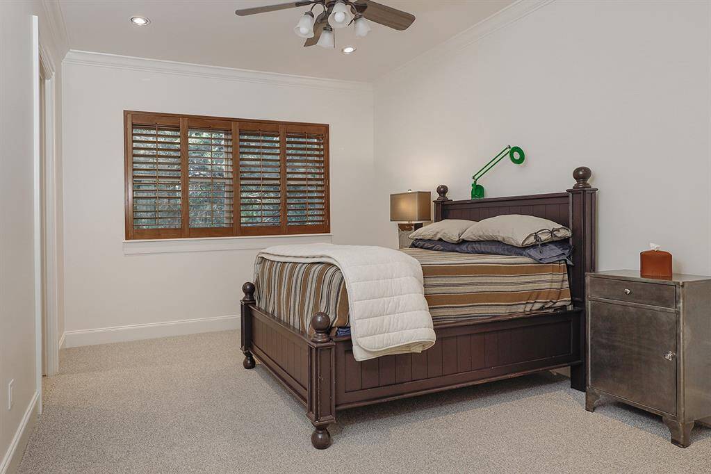 Guest bedroom with plantation shutters, new carpet and crown moulding.