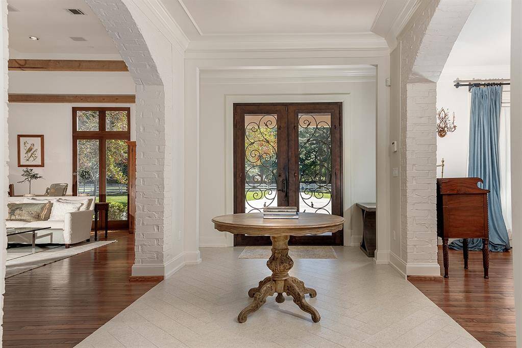 Dual solid iron and glass entry doors lead you inside, where you'll find new herringboned tile flooring and stunning original hardwood floors.