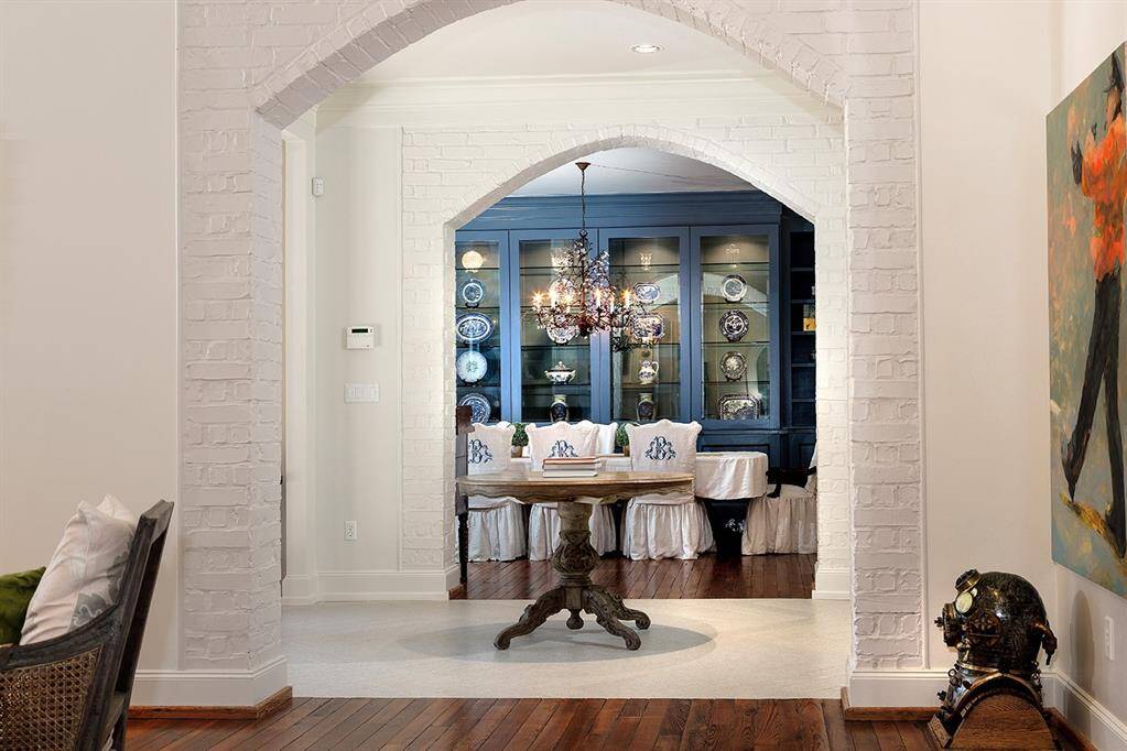 A view of the formal dining room with built-in china cabinet and painted brick archway.