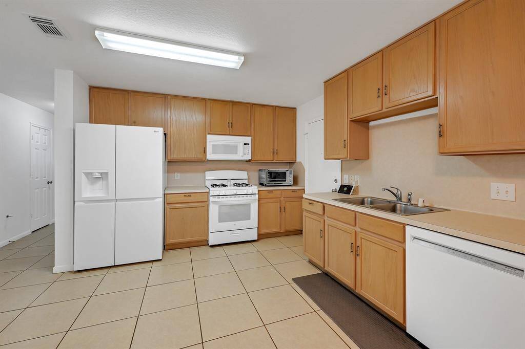 The kitchen at 21215 Bridge Springs Ln is past the Family Room and is also quite spacious. It overlooks the Family Room and has access to the garage. This room also enjoys a great breakfast area. The downstairs of the home has no carpet, and it features large neutral tile with complementary grout. The paint is a bright color. The windows have gorgeous cordless light filtering roller shades in Serene White in the whole home.
