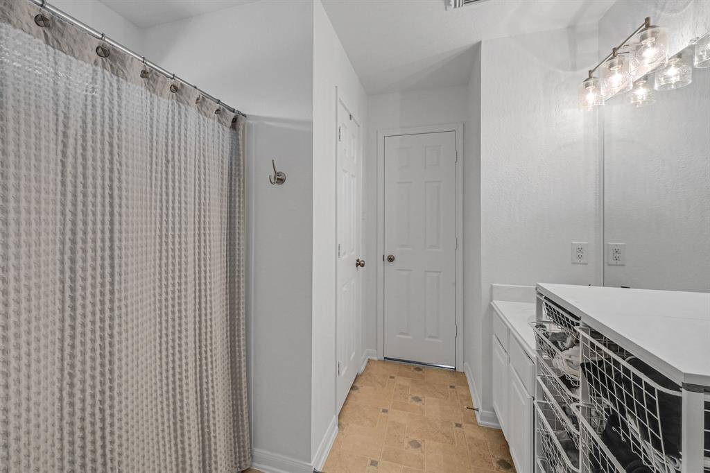The Primary Bathroom at 21215 Bridge Springs Ln, is a great space. The upstairs of the home has no carpet, and it features neutral tile which adds to the cozy feel to the upstairs. The paint in the Primary Bathroom is a bright color. The light fixtures in the Primary Bathroom were recently updated.