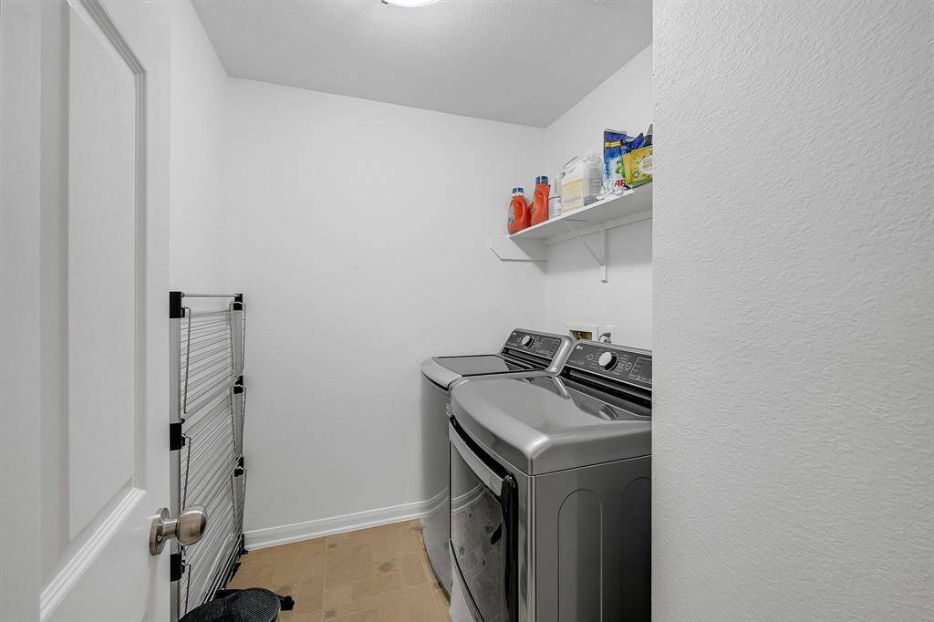 The Laundry Room at 21215 Bridge Springs Ln, is upstairs and is a great space. The upstairs of the home has no carpet, and it features neutral tile keeping with the cozy feel to the upstairs and home. The paint is a bright color, and there is enough storage to keep all the things needed to clean the laundry in the home.