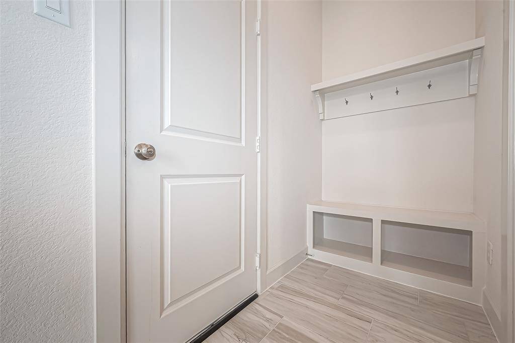 Stay organized and clutter-free in this practical and stylish mudroom area with ample storage for shoes, accessories, convenient bench seating and hooks.