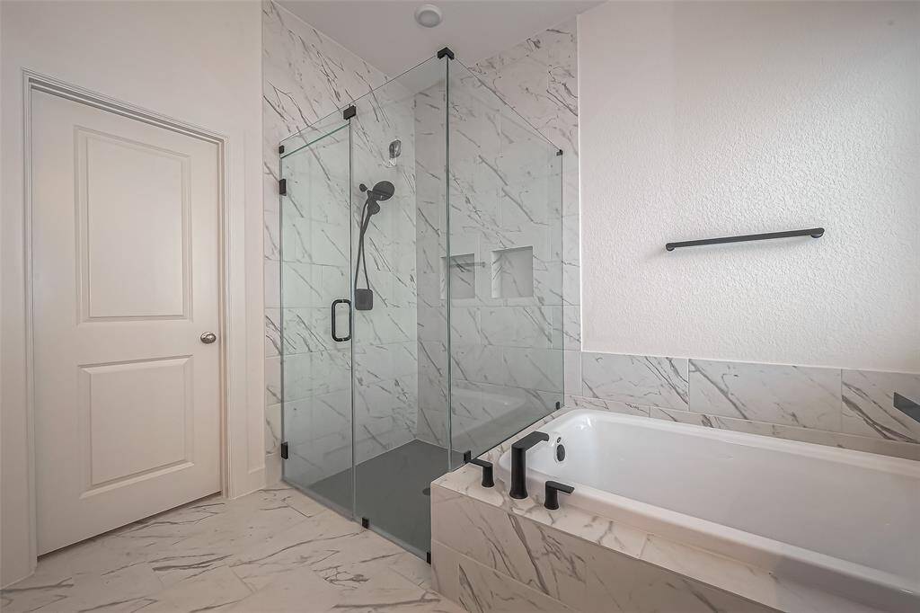 Another view of the frameless shower and huge soaking tub.  Notice how shower tile goes to up to the ceiling and surrounds the tub.