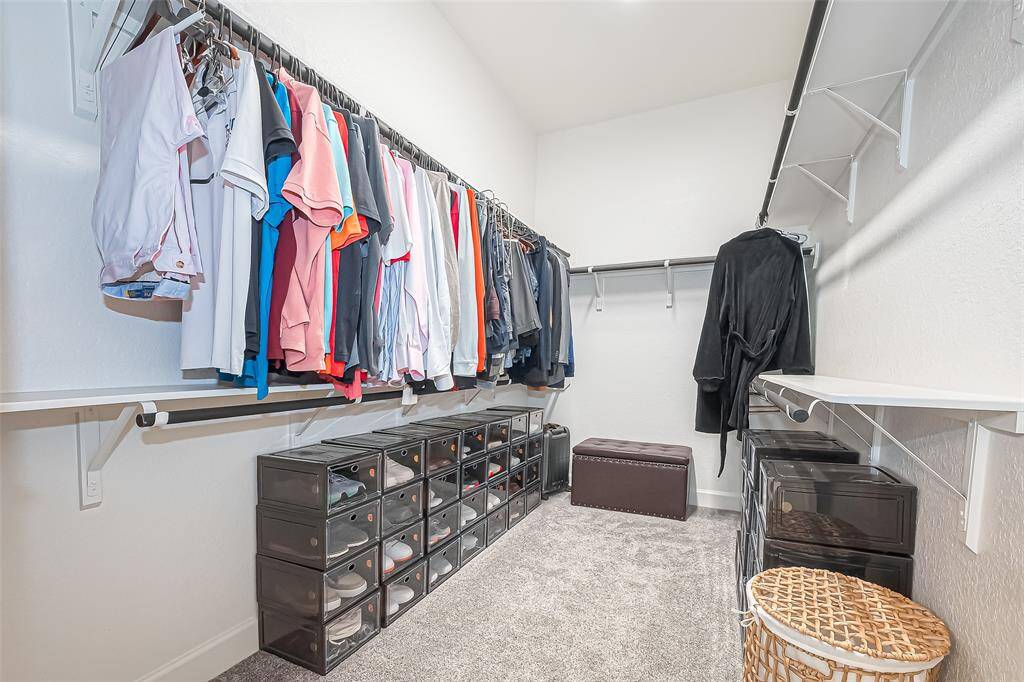 This expansive primary closet offers ample space to showcase your entire wardrobe.