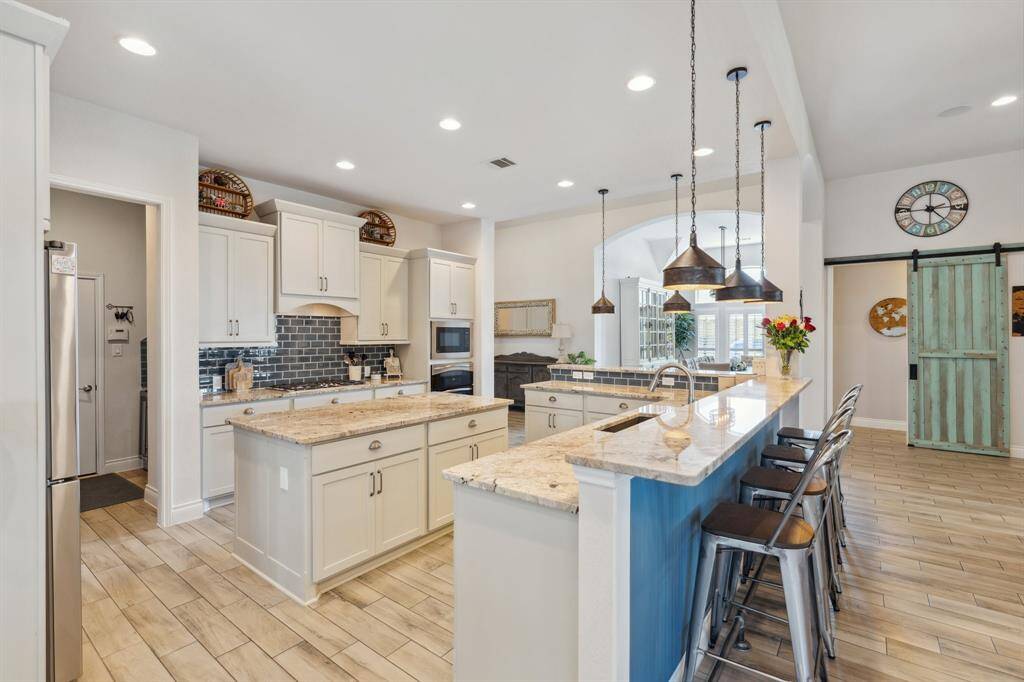 A closer view of the breakfast bar, featuring elegant granite countertops and stylish pendant lighting